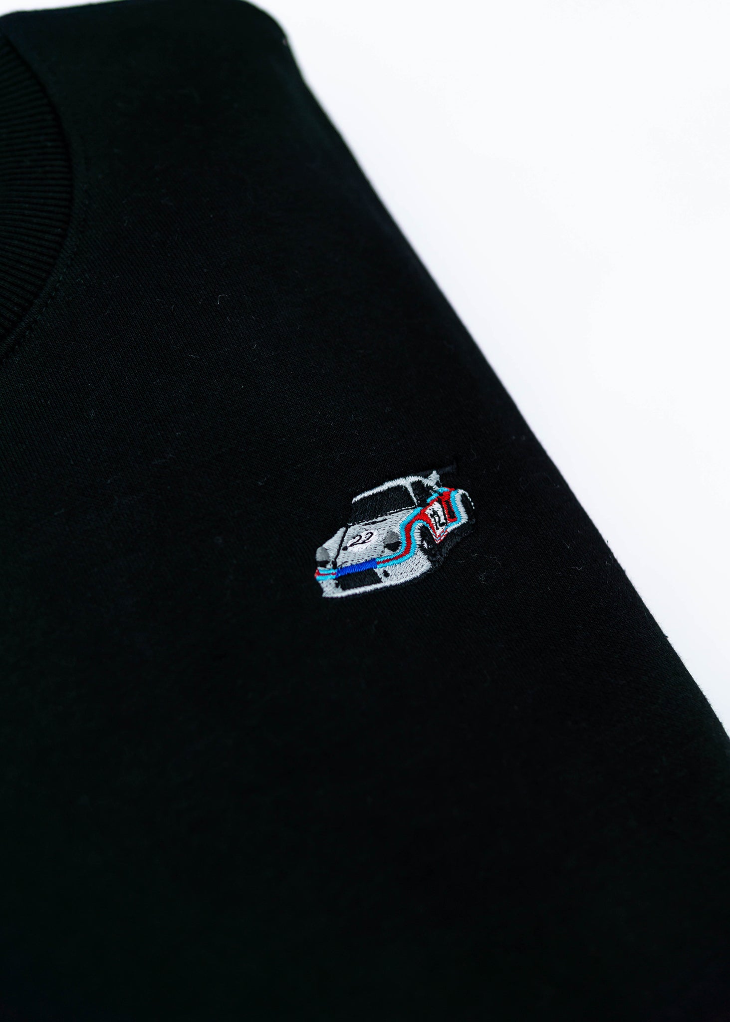 A black 911 RSR 2.1 Turbo crewneck sweater for men. Photo is a close up of the sweater with an embroidered 911 RSR 2.1 Turbo. Fabric is a cotton and polyester mix and high quality and fits to size. The style is long sleeve, crew neck, and embroidery on left chest.