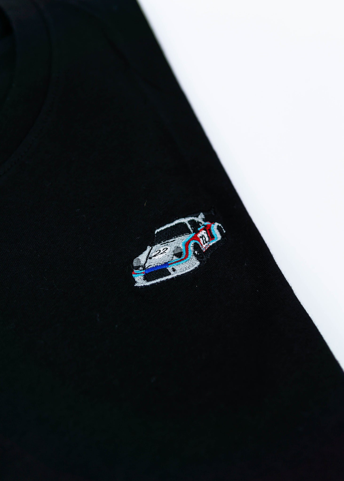 A black 911 RSR 2.1 Turbo T-Shirt for men. Photo is a close up view of the shirt with an embroidered 911 RSR 2.1 Turbo. Fabric composition is 65% polyester, and 35% cotton. The material is very stretchy, soft, comfortable, breathable, and non-transparent. The style of this shirt is short sleeve, with a crewneck neckline.