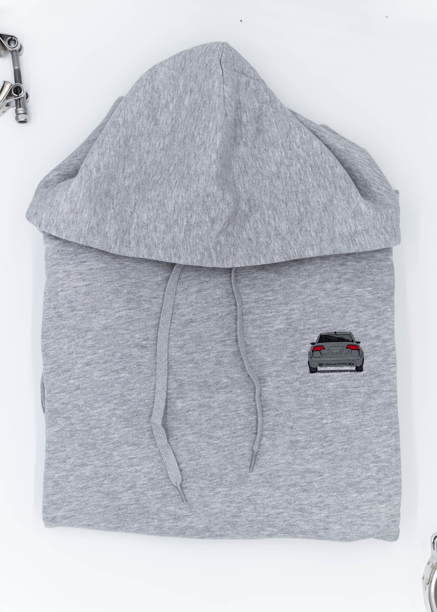 A grey B7 RS4 unisex hoodie for men and women. Photo is a close up view of the sweater with an embroidered grey B7 RS4. Fabric composition is cotton, polyester, and rayon. The material is very soft, stretchy, and non-transparent. The style of this hoodie is long sleeve, crewneck with a hood, hooded, with embroidery on the left chest.