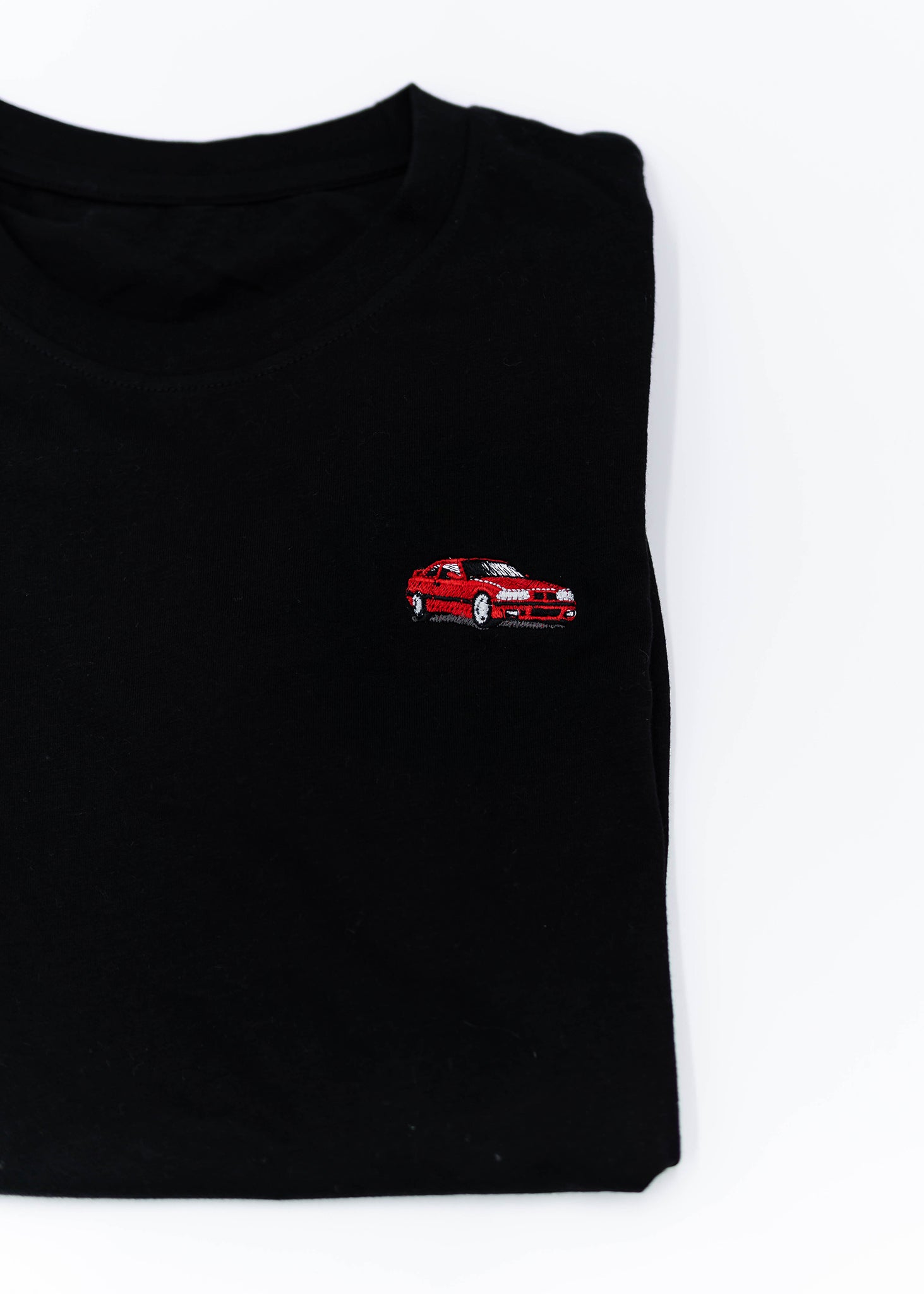 A black E36 M3 T-Shirt for men. Photo is a close up view of the shirt with an embroidered red E36 M3. Fabric composition is 65% polyester, and 35% cotton. The material is very stretchy, soft, comfortable, breathable, and non-transparent. The style of this shirt is short sleeve, with a crewneck neckline.