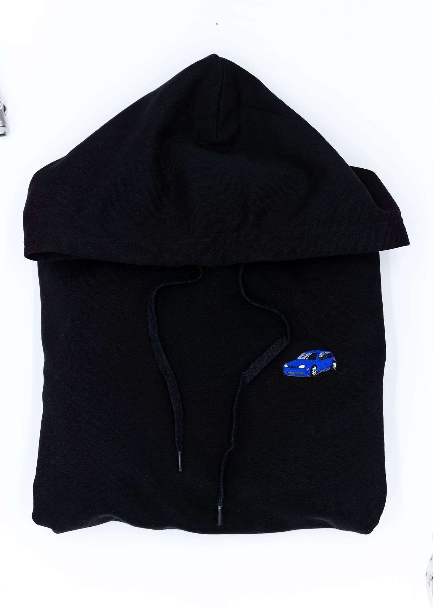 A black Mk4 Golf R32 unisex hoodie for men and women. Photo is a close up view of the sweater with an embroidered blue Mk4 Golf R32. Fabric composition is cotton, polyester, and rayon. The material is very soft, stretchy, and non-transparent. The style of this hoodie is long sleeve, crewneck with a hood, hooded, with embroidery on the left chest.